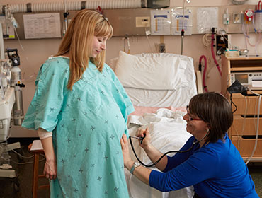 Photo of labouring person at hospital with midwife.