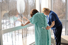 Midwife and client standing at window.